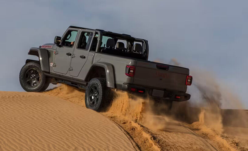 The 2023 Jeep Gladiator Mojave cresting a sand dune