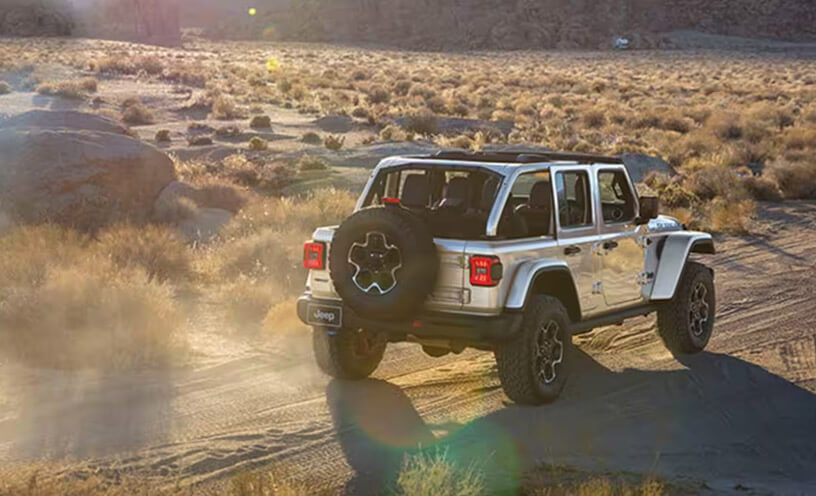 The 2023 Jeep Wrangler Rubicon being driven on a dirt road in the desert